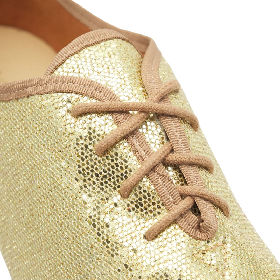 Nahaufnahme von JZE79 Rumpf So Danca Gold Jazzschuhen mit beigen Schnürsenkeln, die ihr glänzendes Obermaterial zur Geltung bringen.